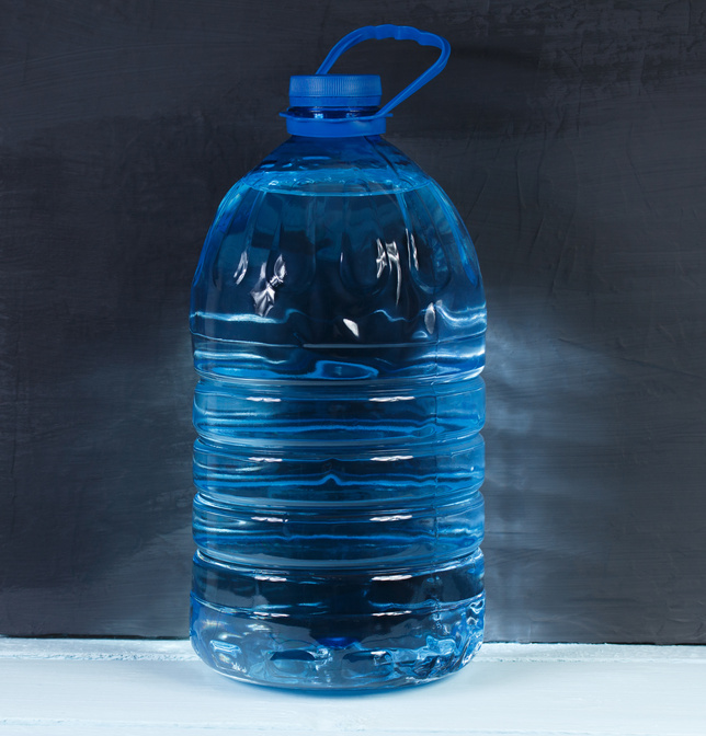 5 liters. Big plastic bottle of potable water on a dark background.